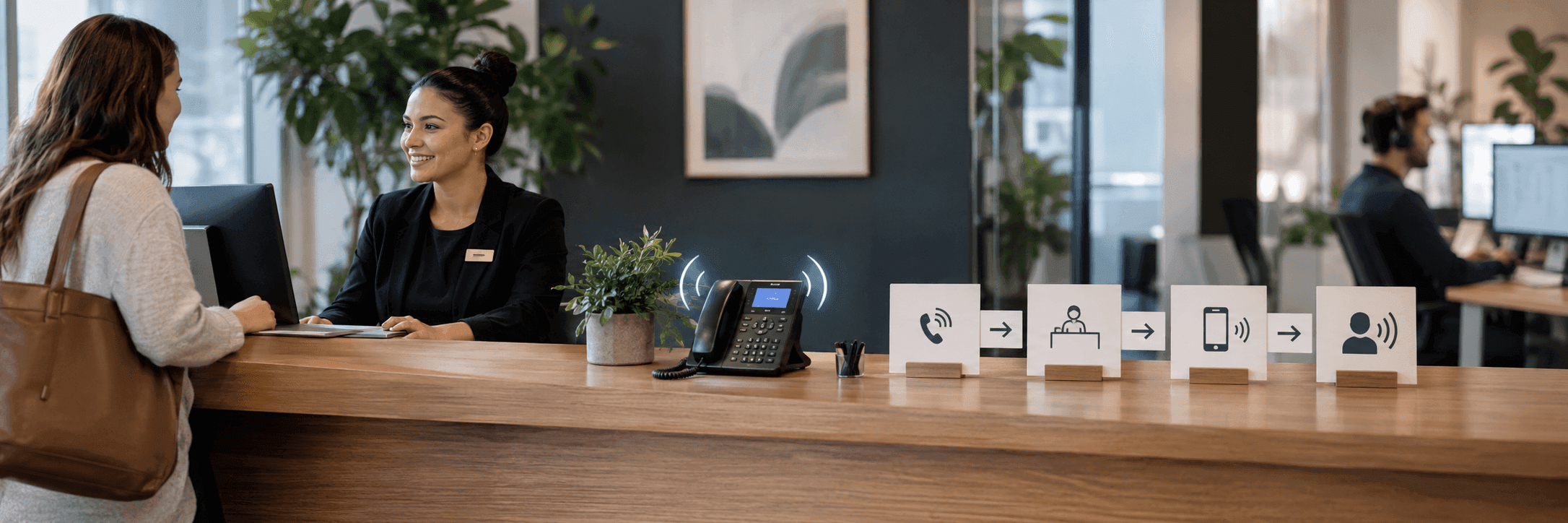 Une réceptionniste aide un visiteur pendant qu'un téléphone qui sonne est répondu simultanément.